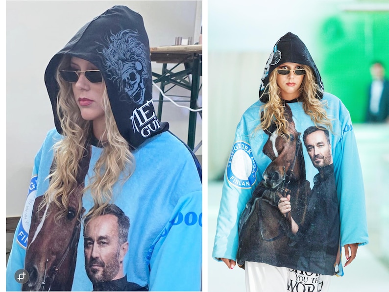 Pu&ograve; includere: Una felpa con cappuccio azzurra caratterizzata da una grande stampa fotografica di un uomo e un cavallo sul davanti. Il cappuccio nero mostra una grafica di un teschio con piume e il testo "MET GUIL". Le maniche sono azzurre con loghi circolari.