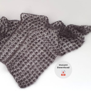 Peut inclure: Un châle gris foncé à tissage ouvert avec un motif délicat et en dentelle. Le châle est drapé sur une surface blanche, mettant en valeur son design et sa texture complexes. L'image comprend un petit graphique avec les mots "Téléchargement instantané".