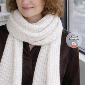 May include: A thick, cream-coloured knitted scarf, wrapped around the neck. The scarf has a textured appearance and a simple design. The image includes a circular graphic with the words "Instant Download" and a PDF icon.