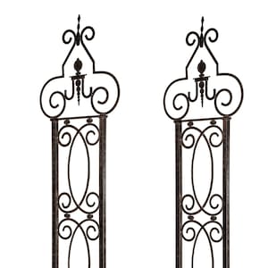 May include: Two black metal garden trellises with ornate scrollwork designs. Each trellis has a decorative finial at the top and a sturdy base.