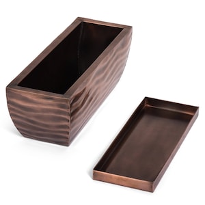 May include: A copper-colored metal planter with a wavy texture. The planter has a matching tray.