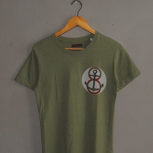 May include: A green short-sleeved t-shirt with a red and white anchor graphic on the front.