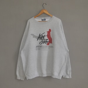 May include: Grey sweatshirt with a red and black graphic of a person dancing. The graphic includes the text "Art for the Soul" and "Ad'Fam Clothing".