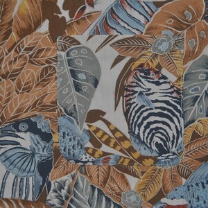 May include: A white fabric with a tropical print featuring brown, blue, and white fish, leaves, and flowers.