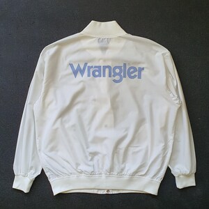 Op de afbeelding: Witte windbreaker jack met een blauw "Wrangler" logo op de rug.