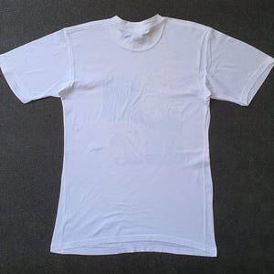 May include: A plain white t-shirt with a crew neck and short sleeves.