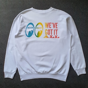May include: White sweatshirt featuring the text "MOON Equipped" and "WE'VE GOT IT ALL" in a rainbow gradient. The sweatshirt has a crew neck and long sleeves. The graphic is on the back of the sweatshirt.