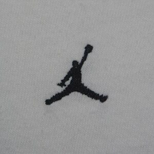 K&ouml;nnte beinhalten: Schwarz-wei&szlig;e Silhouette einer springenden Person, ein beliebtes Logo f&uuml;r eine Sportbekleidungsmarke.