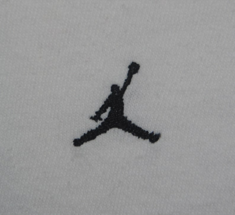 K&ouml;nnte beinhalten: Schwarz-wei&szlig;e Silhouette einer springenden Person, ein beliebtes Logo f&uuml;r eine Sportbekleidungsmarke.