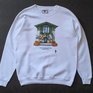 Puede incluir: Sudadera blanca de manga larga con un estampado gráfico de una casa con molduras verdes y el texto "The Dana Thomas House, Springfield, Illinois".
