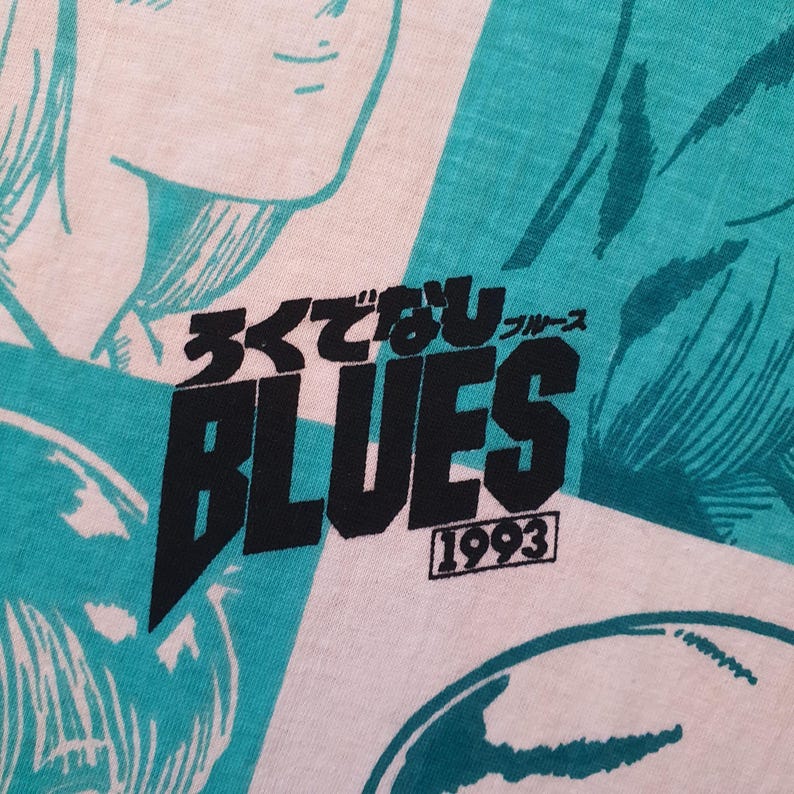 May include: A white t-shirt with a blue and white graphic print. The graphic features the text "まことなりBLUES" and "1993".