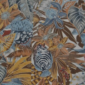 May include: A white fabric with a tropical print featuring blue and brown fish, yellow and brown flowers, and green leaves.