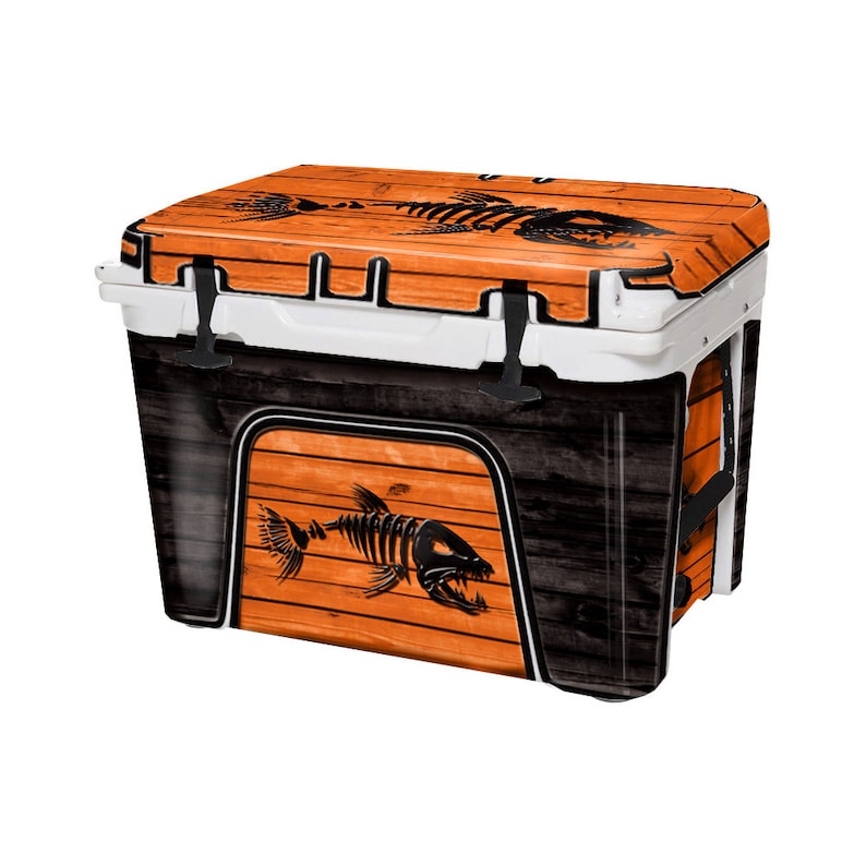 K&ouml;nnte beinhalten: Eine schwarze und orangefarbene K&uuml;hlbox mit Holzmaserung und einem Fischskelett-Motiv. Die K&uuml;hlbox hat einen wei&szlig;en Deckel und schwarze Griffe.