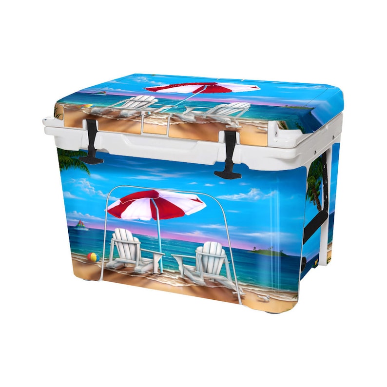 May include: White cooler with a beach scene design. The cooler features two white chairs under a red and white umbrella on a sandy beach with blue water and palm trees.