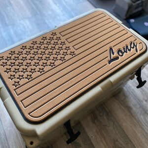 Puede incluir: Una nevera beige con un dise&ntilde;o de bandera americana de aspecto de madera y la palabra "Long" en letras negras.