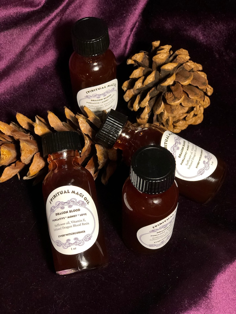 May include: Four small glass bottles with black caps filled with a dark red liquid. The bottles are labeled "Spiritual Magic Oil" and "Dragon Blood Purgative Money Love". The bottles are sitting on a brown pine cone and a purple velvet surface.
