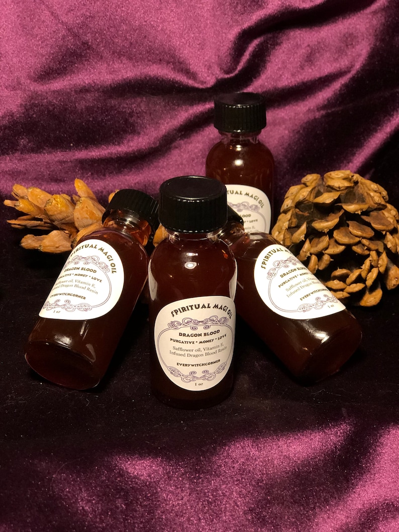 May include: Four small brown glass bottles with black caps filled with a dark red liquid. Each bottle has a white label with black text that reads "Spiritual Magic Oil" and "Dragon Blood Purgative Money Love Safflower oil, Vitamin E, Infused Dragon Blood Resin EveryWitchCorner 1 fl oz".