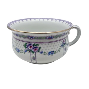 Könnte beinhalten: Weiße Keramik-Toilette mit einem violetten und grünen Blumendesign. Die Toilette hat einen gewellten Rand und einen goldenen Rand.