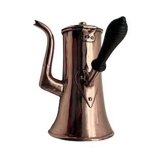 以下が含まれることがあります： ハート型のデザインと黒い木製のハンドルが付いた銅製のコーヒーポット。ポットは光沢のある磨かれた仕上げです。