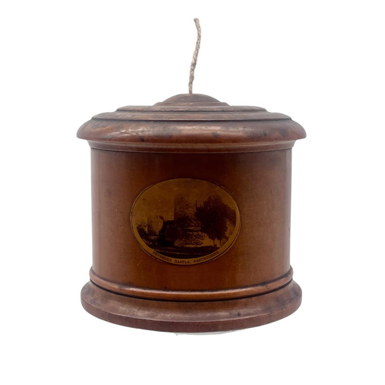 May include: A wooden cylindrical box with a lid and a string attached to the top. The box has a circular image of a castle with the text "PYRAMID CASTLE, SANDWICH, ON" printed on it.