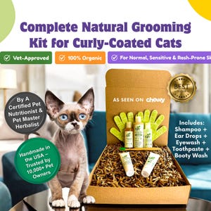 May include: A brown cardboard box with a green and white label that says "AS SEEN ON chewy" and a gold star sticker that says "BEST SELLER". The box is filled with brown packing peanuts and contains a variety of grooming products for curly-coated cats, including shampoo, ear drops, eyewash, toothpaste, and a wash for the rear end. The box is sitting on a table next to a small, light brown cat.