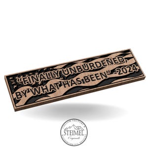 May include: A wooden sign with a black and white American flag design. The sign reads "Finally unburdened, by what has been" - 2024.