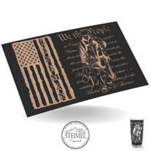 May include: A black and gold design with an American flag and the text "We the People" from the US Constitution. The design features a silhouette of a person holding a hammer and a wrench.
