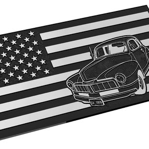 May include: Black and silver rectangular wall art featuring an American flag design with a classic car silhouette. The car has a license plate that reads "CZ 1950". The artwork is a patriotic theme.