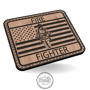 May include: Wooden plaque featuring an American flag design with the words "FIRE FIGHTER" and an illustration of a firefighter. The plaque has a black border and a light brown wood grain finish.