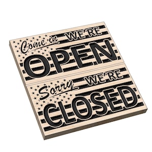 Può includere: Un cartello in legno con un design a bandiera americana in bianco e nero. Il cartello si gira per mostrare "Come in We're Open" da un lato e "Sorry We're Closed" dall'altro.