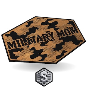 Könnte beinhalten: Ein beiges und schwarzes Tarnmuster mit den Worten "MILITARY MOM" in fetten Blockbuchstaben. Das Design hat eine einzigartige, abgewinkelte Form. Ein kleineres, silbernes und weißes Emblem mit dem Buchstaben "S" befindet sich unten.