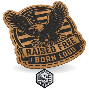 Peut inclure: Un écusson marron avec un aigle noir, un motif de drapeau américain et les mots "RAISED FREE BORN LOUD". L'écusson a une bordure cousue et un petit logo argenté et blanc en bas.