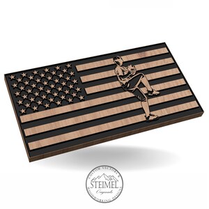 May include: A wooden American flag with a baseball player silhouette in the center. The flag is made of dark wood with a light wood finish. The player is in a pitching stance. The flag is on a white background. The text "CUSTOM VECTORS & STEIMEL Originals WOODWORKING DESIGNS" is on a circular stamp in the lower right corner.