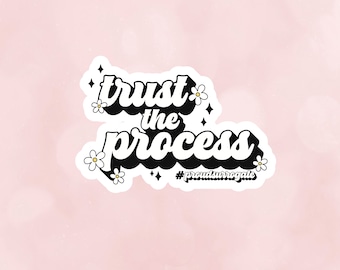 May include: White sticker with black text that reads "trust the process" with a daisy design and the hashtag "#proud surrogate".