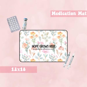 Puede incluir: Una alfombra blanca para medicamentos con un patrón floral y el texto "HOPE GROWS HERE You're planting hope with every brave moment." La alfombra mide 30,5 cm por 45,7 cm.