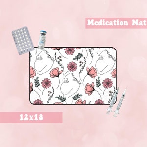Puede incluir: Una alfombra blanca para medicamentos con un patrón floral y el texto "our little" repetido en todo. La alfombra mide 30,5 cm por 45,7 cm.