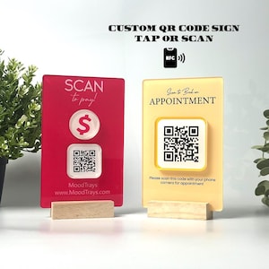 Puede incluir: Dos letreros acrílicos con código QR sobre bases de madera. Uno es rojo con "SCAN to pay!" y un signo de dólar. El otro es amarillo con "Scan to Book an APPOINTMENT". Ambos tienen códigos QR y el texto "CUSTOM QR CODE SIGN TAP OR SCAN".