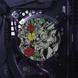 May include: A black and white graphic design of a robot with floral accents. The robot has a skull-like face with red, yellow, and green flowers. The design is on a round, silver-colored surface.