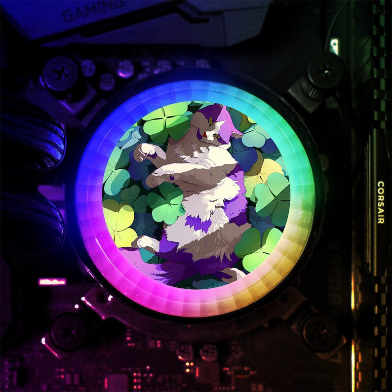 May include: A circular RGB LED light with a white cat with purple stripes lying in a bed of green four-leaf clovers. The light is surrounded by a rainbow-coloured ring.