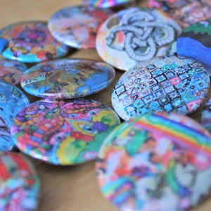 May include: A collection of colourful, round buttons with various designs. The buttons feature abstract patterns, geometric shapes, and whimsical illustrations.