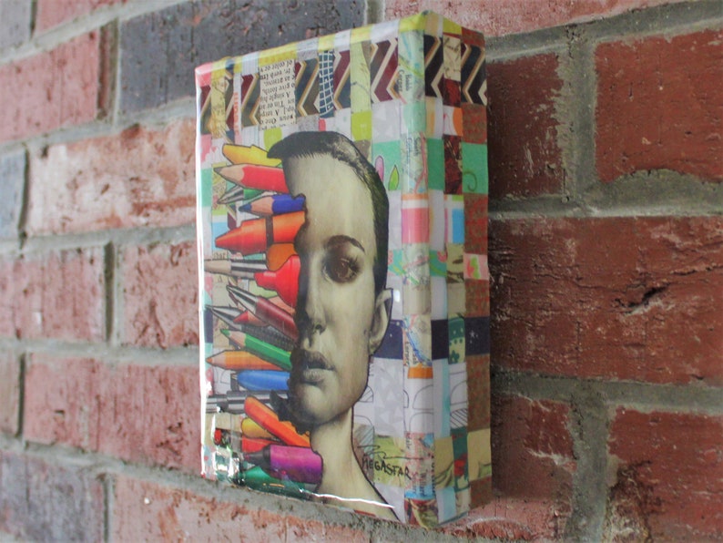 May include: A colorful mixed media artwork featuring a woman's face with a cluster of colored pencils covering half of her face. The background is a collage of colorful patterned paper.