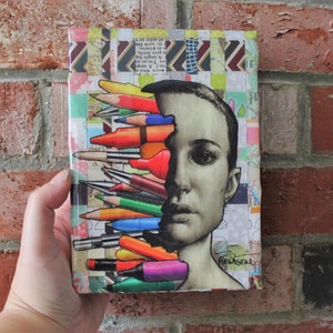 May include: A collage of colorful pencils, crayons, and markers arranged to look like a person's face. The background is a patchwork of colorful paper scraps. The artwork is signed "Megastar".