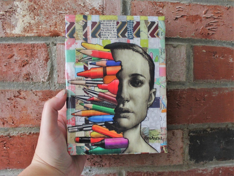 May include: A collage of colorful pencils, crayons, and markers arranged to look like a person's face. The background is a patchwork of colorful paper scraps. The artwork is signed "Megastar".