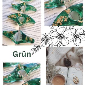 May include: A collection of emerald green resin page holders featuring embedded gold leaf flakes. These smooth, wing-shaped book accessories have a central circular opening designed to hold pages open while reading a book.