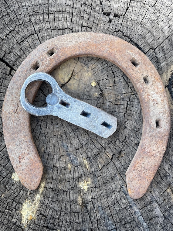 A real blacksmith took an actual vintage horseshoe and hammered it into a bottle opener — history you can crack a beer with.
