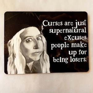 Puede incluir: Un imán rectangular en blanco y negro con una imagen en escala de grises de una mujer con pelo largo y rubio y un sombrero negro. El imán tiene el texto: "Curses are just supernatural excuses people make up for being losers."