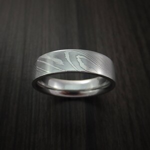 May include: A silver patterned wedding band with a brushed finish.