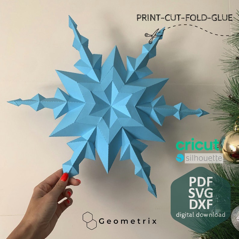 May include: A light blue paper snowflake ornament, ready to be cut, folded, and glued. The snowflake is a 3D design with a star shape in the center. The image includes the text "PRINT-CUT-FOLD-GLUE", "Geometrix", "cricut silhouette", "PDF SVG DXF", and "digital download".