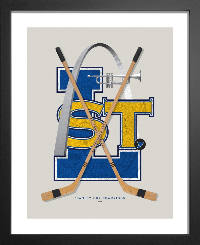 May include: A blue and yellow graphic of the letters "ST" with a map of St. Louis, Missouri inside the letters. The letters are surrounded by a silver arch, and two hockey sticks are crossed behind the letters. The text "STANLEY CUP CHAMPIONS 2019" is below the graphic.