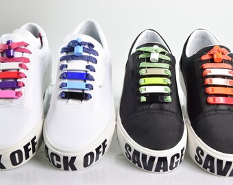 May include: Four pairs of trainers with colourful no-tie shoelaces. The laces are made of elastic and have plastic clips to keep them in place. The trainers have the words "Back Off" and "Savage" printed on them.